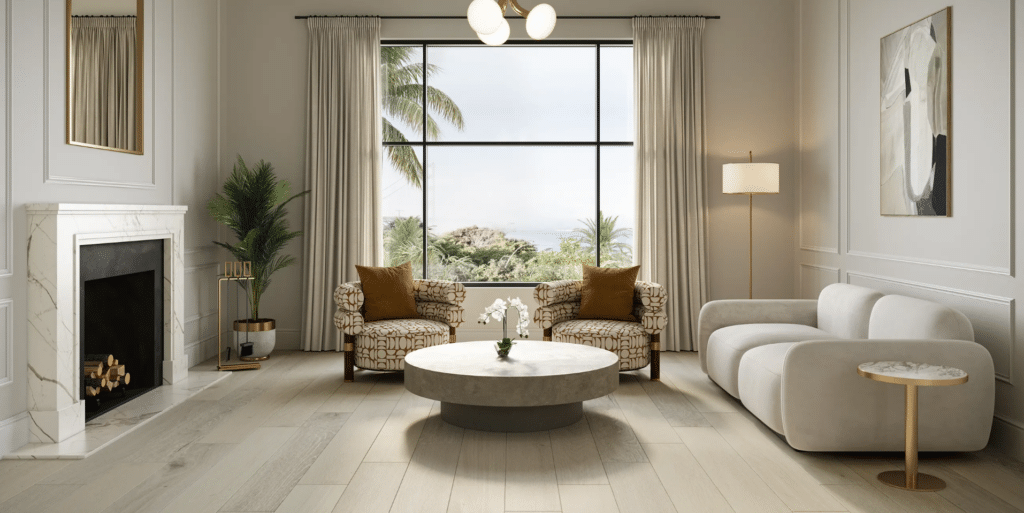 Modern living room with a marble fireplace, two patterned armchairs, a round coffee table, a white sofa, large window with palm trees outside, potted plant, floor lamp, and neutral decor.